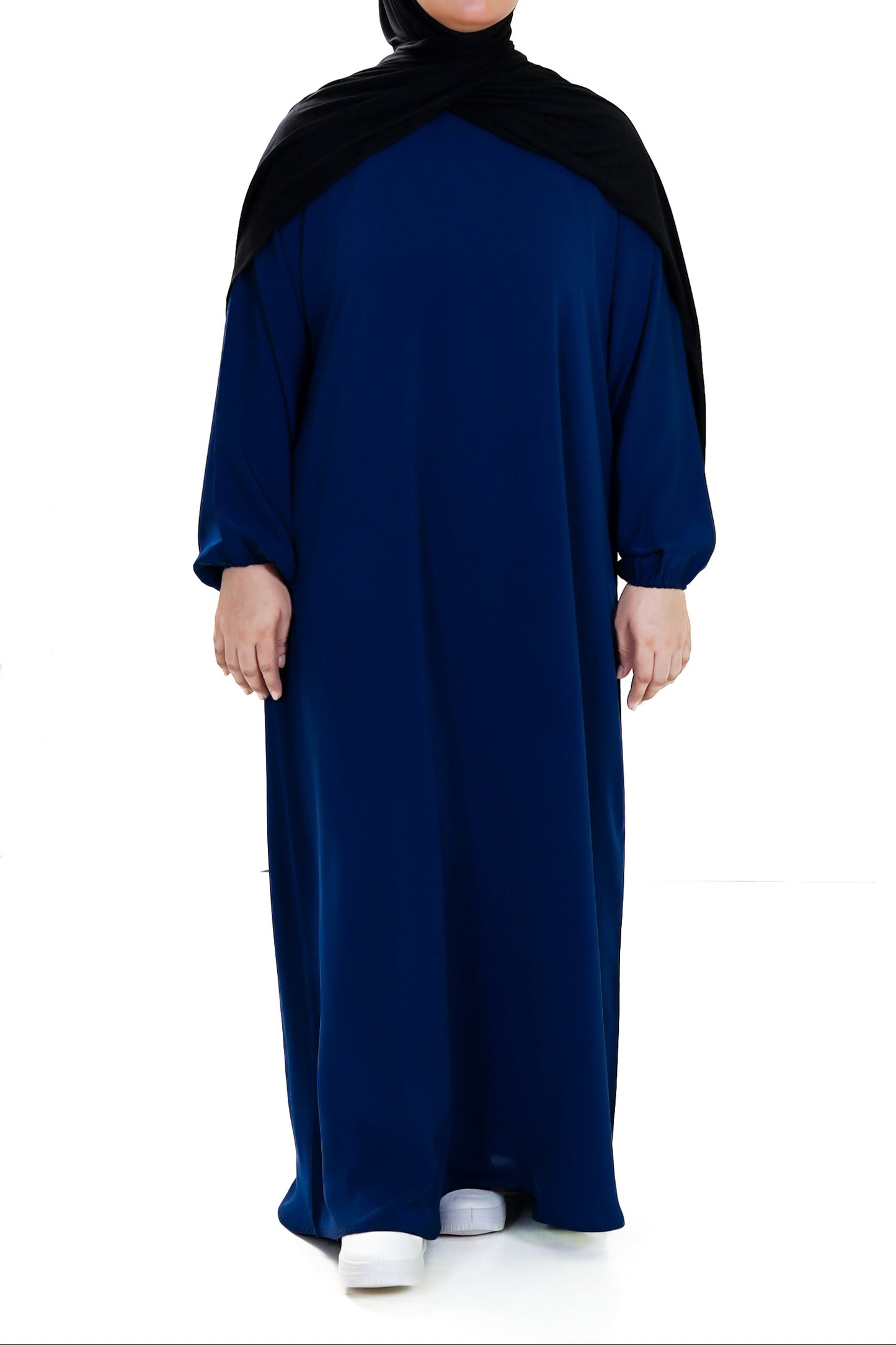 Person wearing a blue abaya with a black hood on a white background
