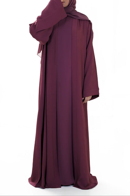 Maroon abaya worn by a model on a white background